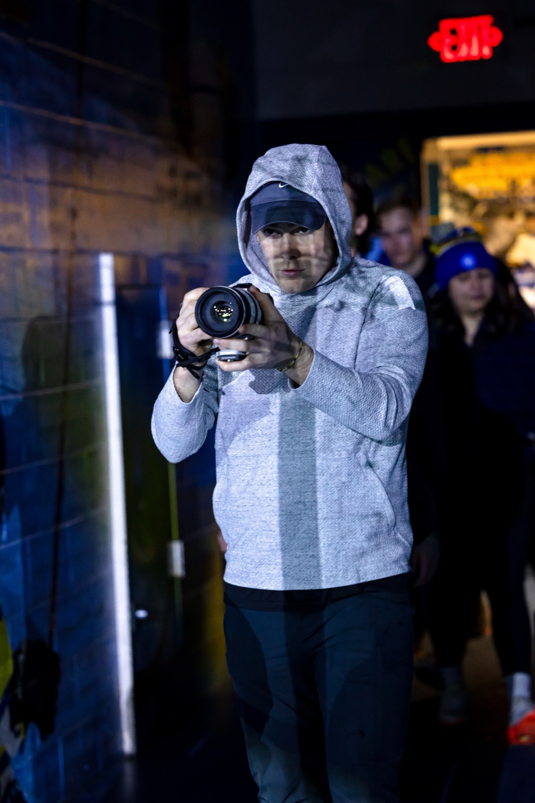 Trevor Earley photographing behind the scenes in an arena hallway