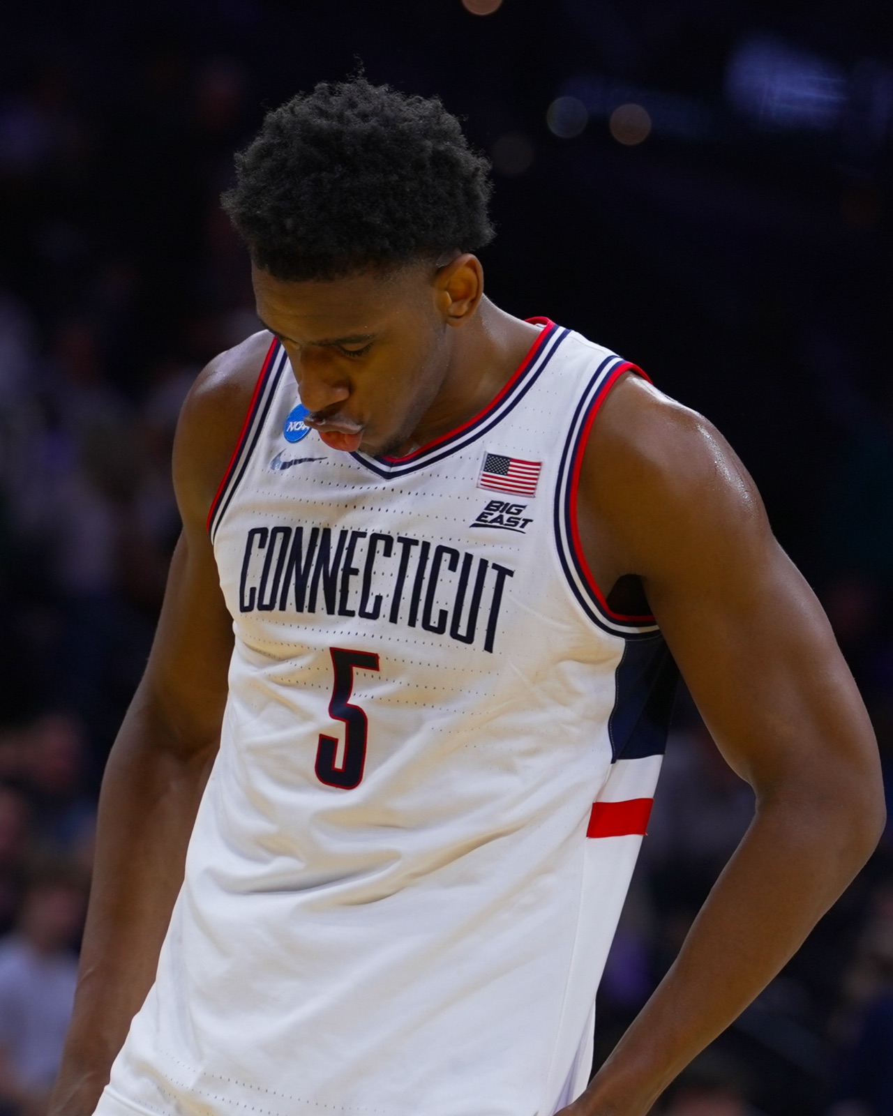 UConn player looking down at his Connecticut jersey during March Madness
